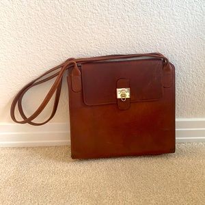 Lancel leather shoulder bag with clasp closure.